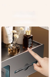 Detail of grey metal wall tissue box showing rounded corners and top storage shelf
