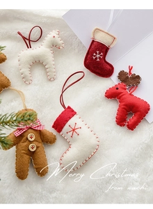 Detail of wool felt gingerbread man and reindeer Christmas ornaments on plush background