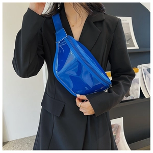 Closeup of a shiny royal blue fashion chest bag worn with a chic black blazer, detail shot