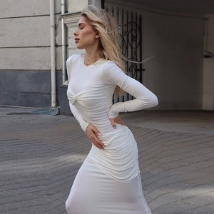 Détail d'une robe moulante blanche à manches longues avec texture plissée et coupe ajustée