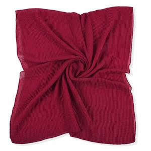 Macro detail of dark red scarf fabric showing elegant vertical pleated texture and material