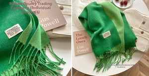 Close-up of a soft gradient green cashmere scarf with delicate woven tassels and fabric label