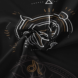 Close-up of black Leo zodiac tapestry fabric with detailed gold lion print patterns
