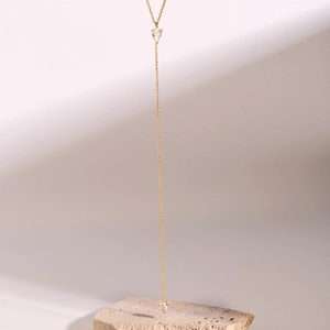 Detailed close-up of golden Y-necklace featuring dual water-drop cubic zirconia pendants