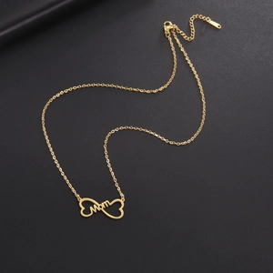 Detailed view of a gold MOM pendant featuring an infinity symbol and a heart on a dark surface