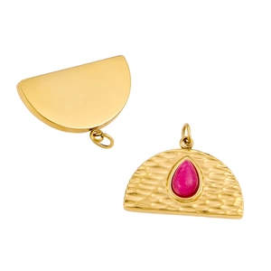 Hammered gold pendant with red teardrop stone and smooth back finish on white background