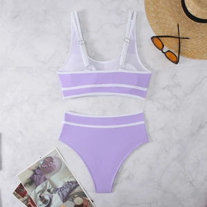 Flat lay of a lavender bikini set with white trim on marble background with summer props