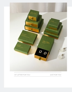 Detailed stack of vintage green jewelry boxes with gold accents and drawer design