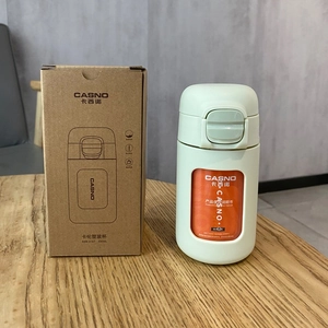 Detailed view of the 330ml green glass travel mug alongside its original kraft paper box