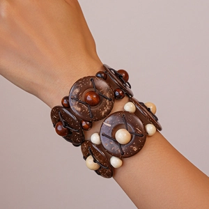 Gros plan d'un bracelet bohème multicouche avec perles de coco et de bois porté au poignet