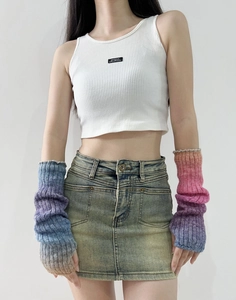 Close-up of rainbow gradient knit arm warmers paired with a white ribbed knit vest