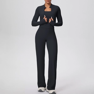 Détail de la veste de yoga noire avec passe-pouces et pantalon large à taille haute