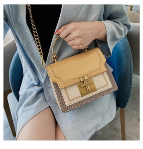 Detail of light brown and cream leather bag with woven side and gold chain strap