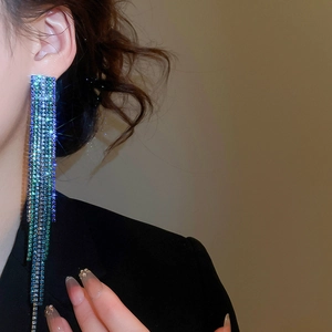 Detail of teal gradient tassel earrings with rhinestones draped on person for elegant look