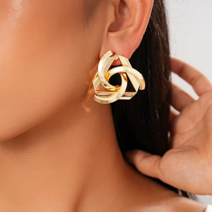 Macro detail of geometric hollow golden triangle earrings worn on model ear