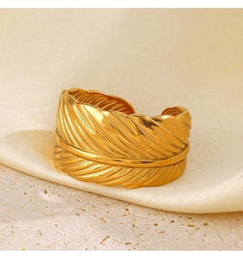 Macro shot of gold feather ring texture on silk fabric and sandstone base