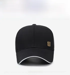 Front view of black cotton baseball cap with white brim edge and small gold metal badge