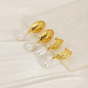 Vue détaillée des boucles d'oreilles perles dorées en forme de goutte d'eau polies