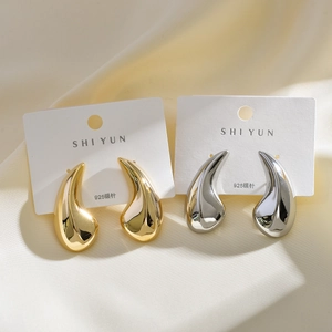 Close-up of gold and silver teardrop earrings on 925 silver needles and display card