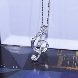 Macro detail of silver G-clef pendant necklace with shimmering white cubic zirconia stones
