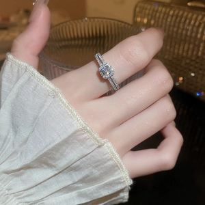 Detail of cushion cut halo zircon ring in silver finish on a model's hand