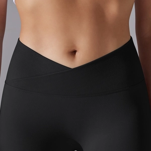 Close-up of black high-waisted yoga leggings with V-shaped criss-cross waistband detail
