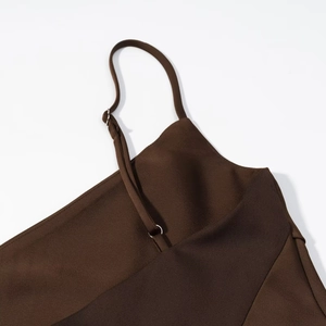Detail of adjustable thin shoulder straps and silk satin texture on dark brown top