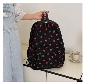 Detail of black corduroy backpack with red strawberry print and front zipper pocket