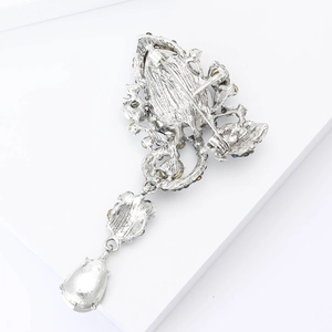Detail view of the silver alloy brooch back featuring relief texture and pin clasp