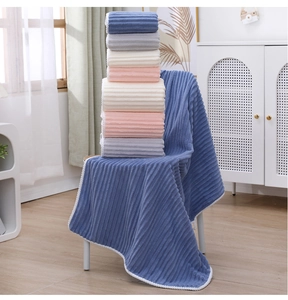 Detail of coral fleece striped towels showing soft texture in blue, pink, and beige