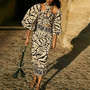 Detail of two-piece swimwear set with halter top and high-waisted printed midi skirt