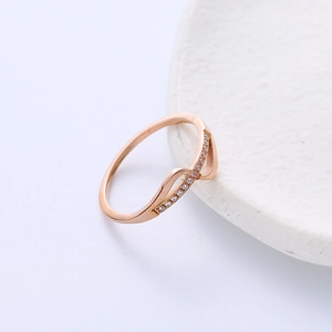 Bague vague en or rose élégante avec pavé de zircons blancs sur support en pierre claire
