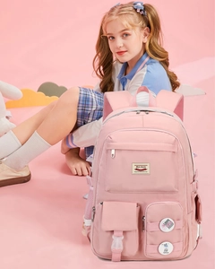 Close-up of pink school backpack with multi-functional pockets and cute decorative badges