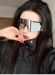 Close-up of futuristic silver mirrored cycling sunglasses with a black frame on a model