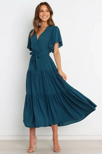 Detalle del vestido cruzado color cerceta con cuello en V y falda larga escalonada
