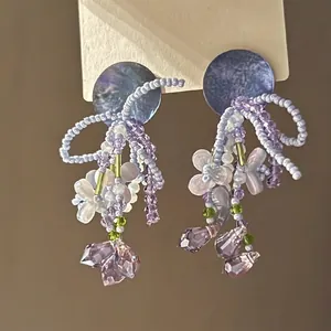 Macro detail of lavender beaded flower earrings with glass crystals and tassels