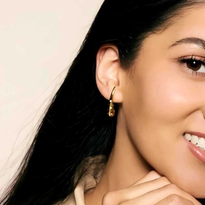 Polished 18K gold-plated teardrop earrings shown on model for elegant daily wear