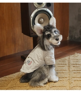 Close-up of quilted cream pet vest with vitality dog embroidery on a wooden floor