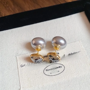 Detailed macro shot of square diamond stud earrings with gray pearls on a display card