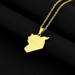 Detail of gold Syria map necklace with engraved city names like Halab and Hims on black texture