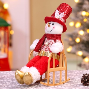 Macro view of Christmas snowman doll with red sequins sitting on a miniature rocking chair