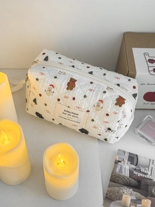 Dettaglio della trousse trapuntata bianca con stampe natalizie di pupazzi di neve e orsi