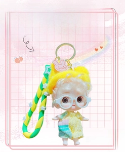 Macro detail of the cute princess doll keychain with silver hair and colorful hand strap