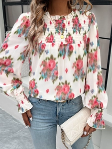 Close-up of floral chiffon blouse with pleated high neck and smocked yoke detail