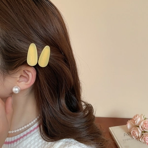 Détail d'une pince à cheveux goutte en acrylique jaune avec texte France Handmade