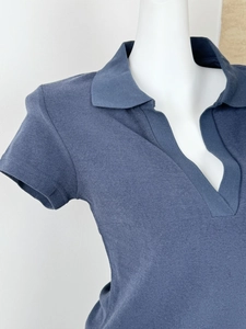 Macro view of navy knit polo shirt showing the collar design and fabric texture