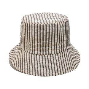 Detail of striped sun hat with sparkling rhinestones on brown and white fabric