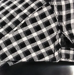 Macro view of detailed stitching on black and white plaid beret fabric edge