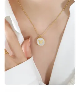 Detailed view of a gold butterfly charm necklace with a white shell inlay on a bead chain