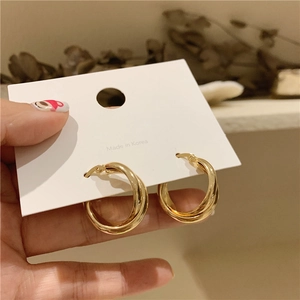 Detail of gold double-layer geometric hoop earrings on a minimalist Korean card